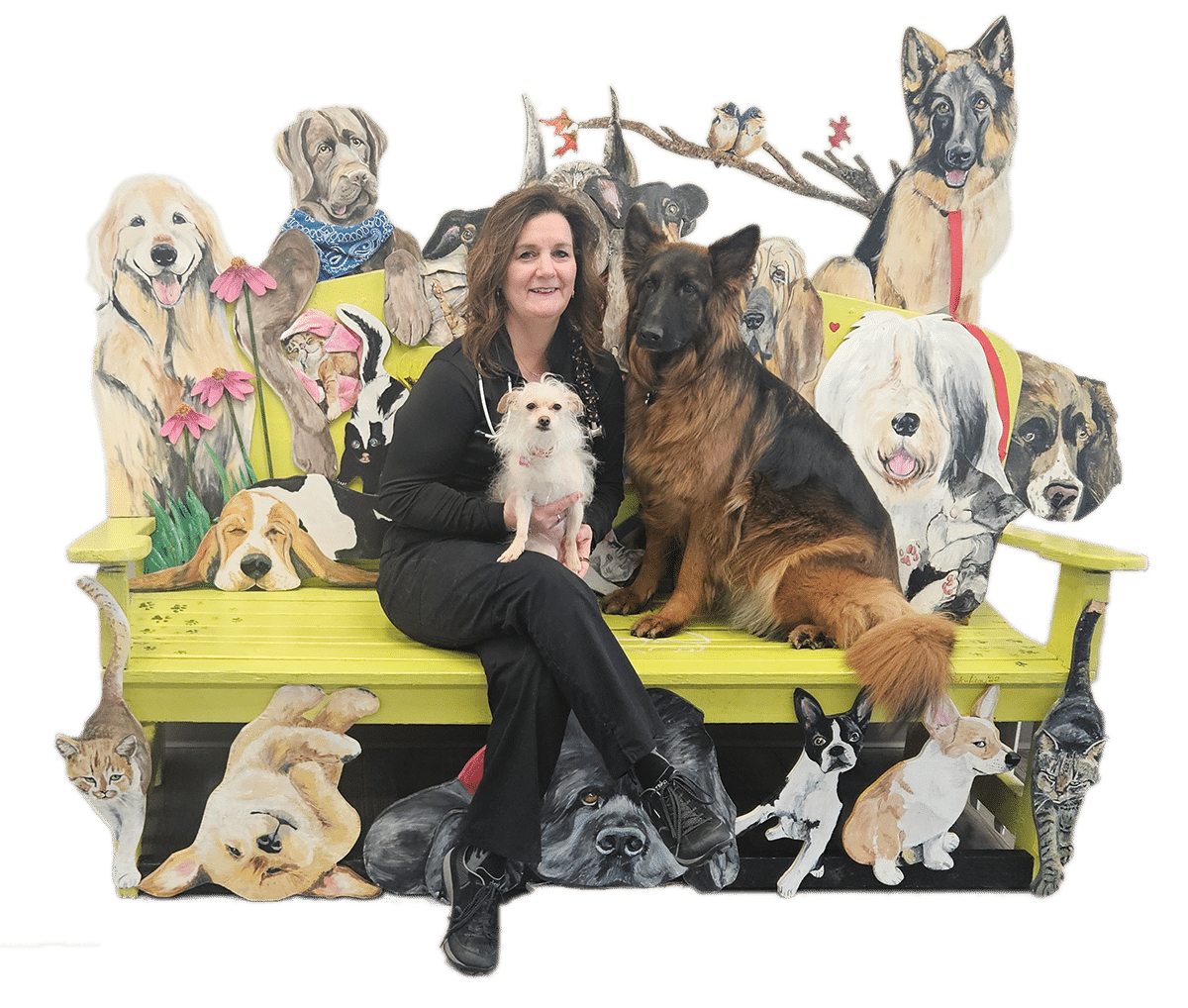 A woman sits on a colorful bench with two dogs, surrounded by painted images of various animals.